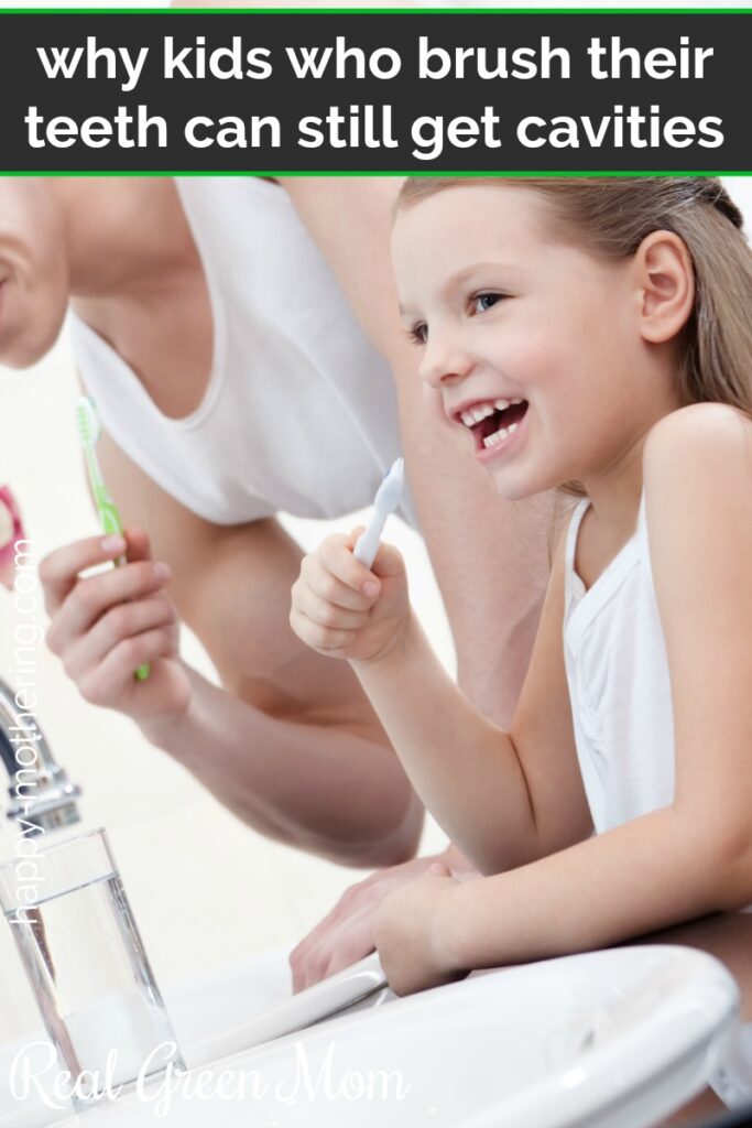 Little girl smiling and brushing her teeth with her dad