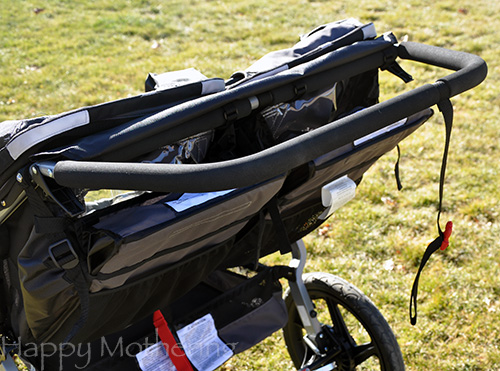 Large padded handle bar of the BOB Revolution Duallie Stroller parked on grass