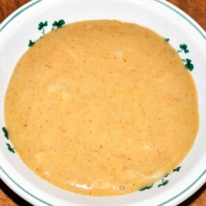 Overhead view of homemade pumpkin pudding in a white bowl with green embellishments