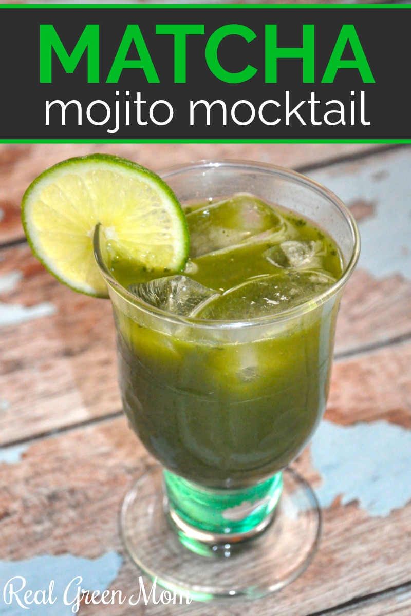 Matcha mojito mocktail in decorative glass garnished with lime wedge, sitting on blue paint worn wood table