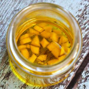 Glass jar filled with garlic oil for earaches