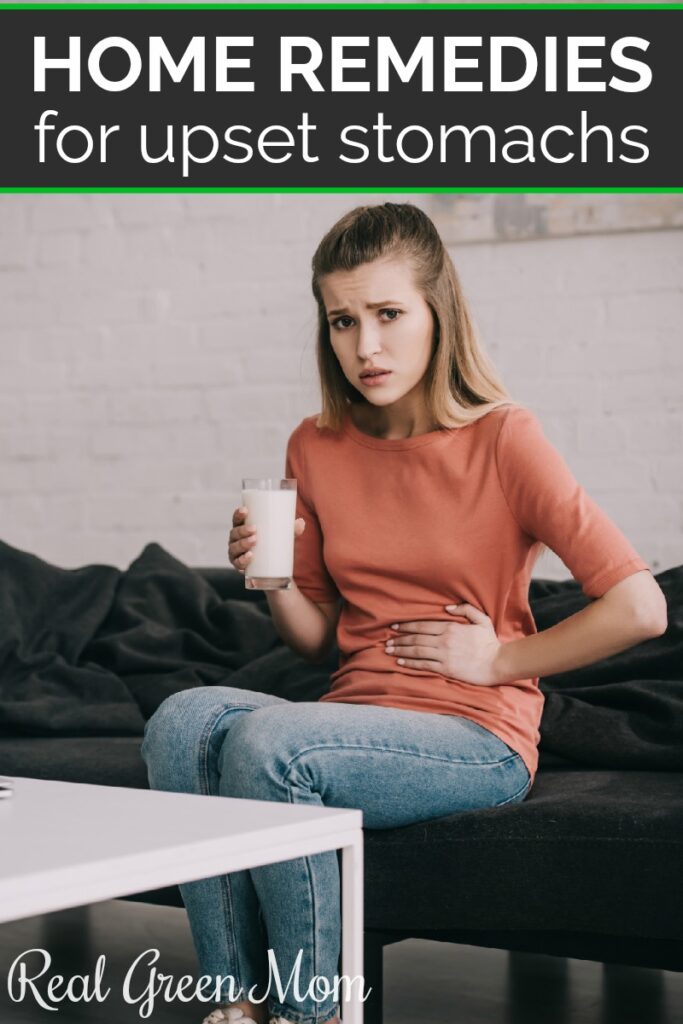 Woman holding her stomach while drinking a glass of milk