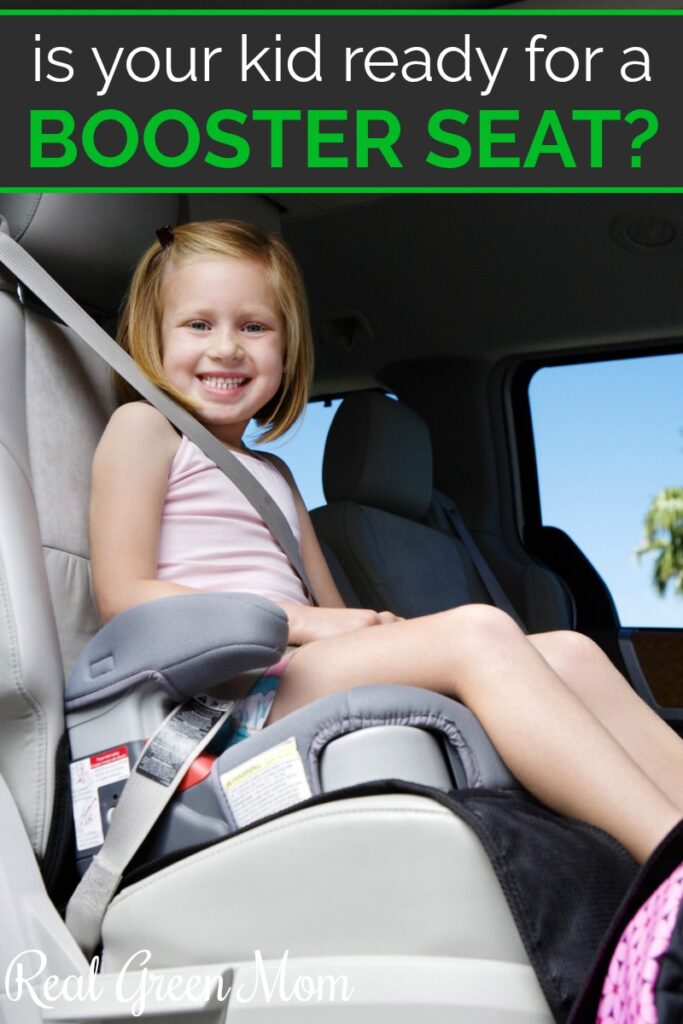 Little girl strapped into her booster seat in the back seat of a car