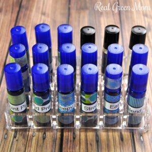 18 blue essential oil roller bottles labeled with blend names and organized in a lipstick organized