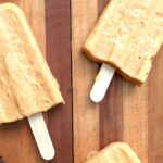Close up of homemade pumpkin yogurt popsicles on a wood cutting board ready to eat