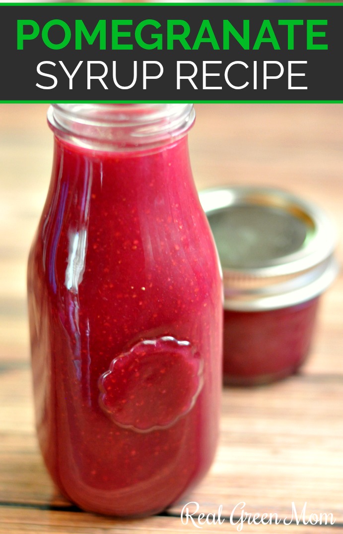 Glass milk jar filled with pomegranate syrup in front of a 4 ounce mason jar of syrup on a brown wood table