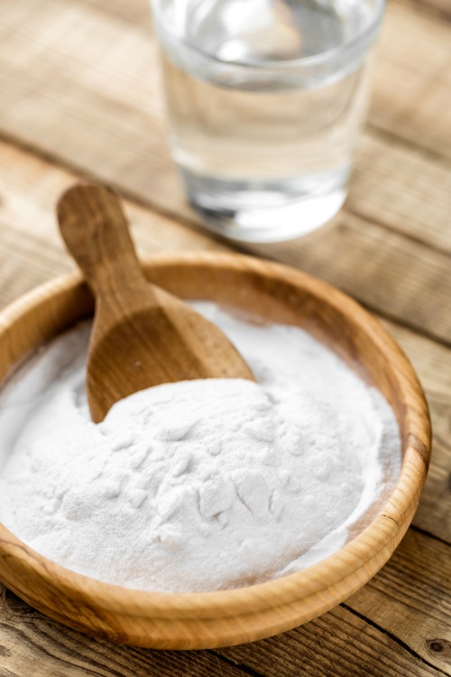 Baking soda in a wood bowl with a scoop