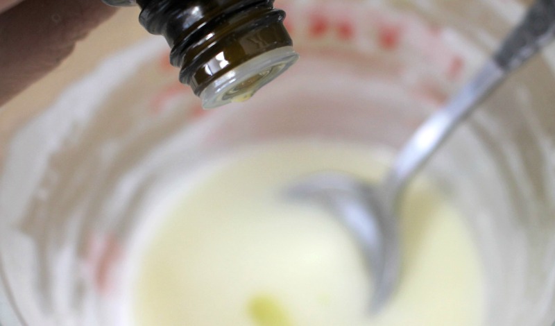 Essential oil drops being added to melted soap and oil mixture