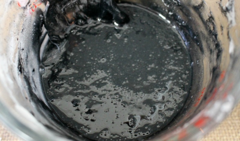 Activated charcoal soap bar mixture melted in a glass measuring cup