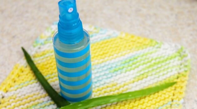 Spray bottle of after sun spray with aloe on a dishcloth