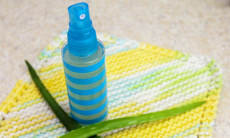 Spray bottle of after sun spray with aloe on a dishcloth