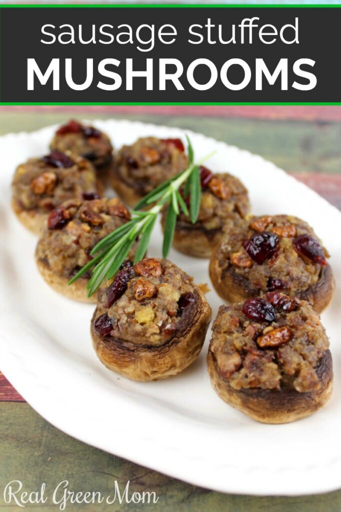 Serving platter of sausage stuffed mushroom with a rosemary sprig garnish