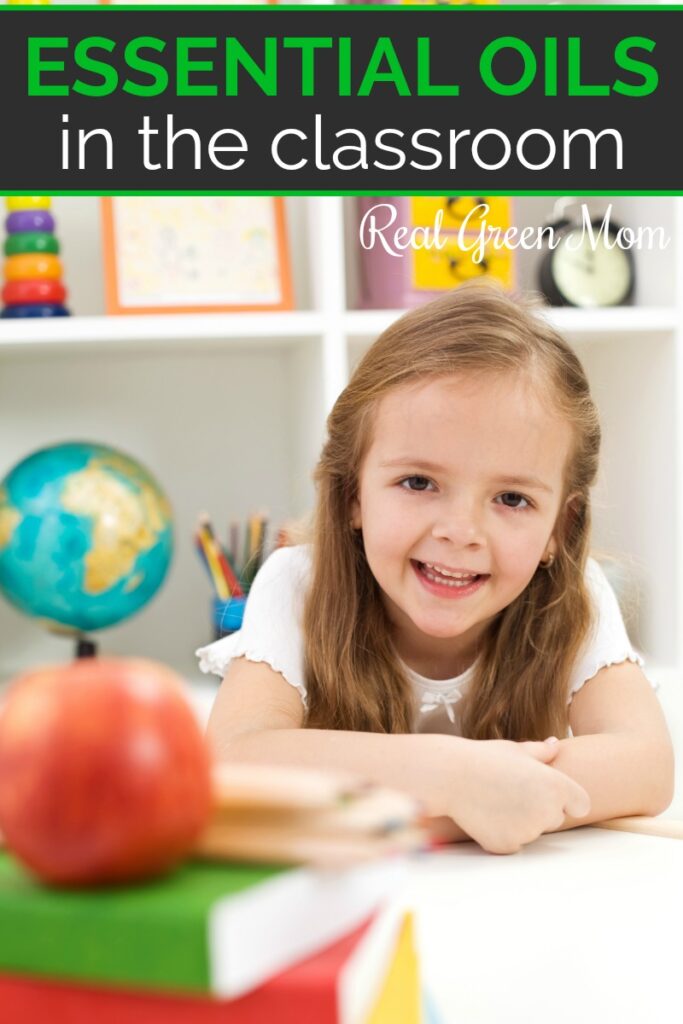 Little girl sitting at her desk on the classroom with books, an apple, globe and more