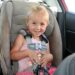 Kaylee buckled into her car seat while on a road trip